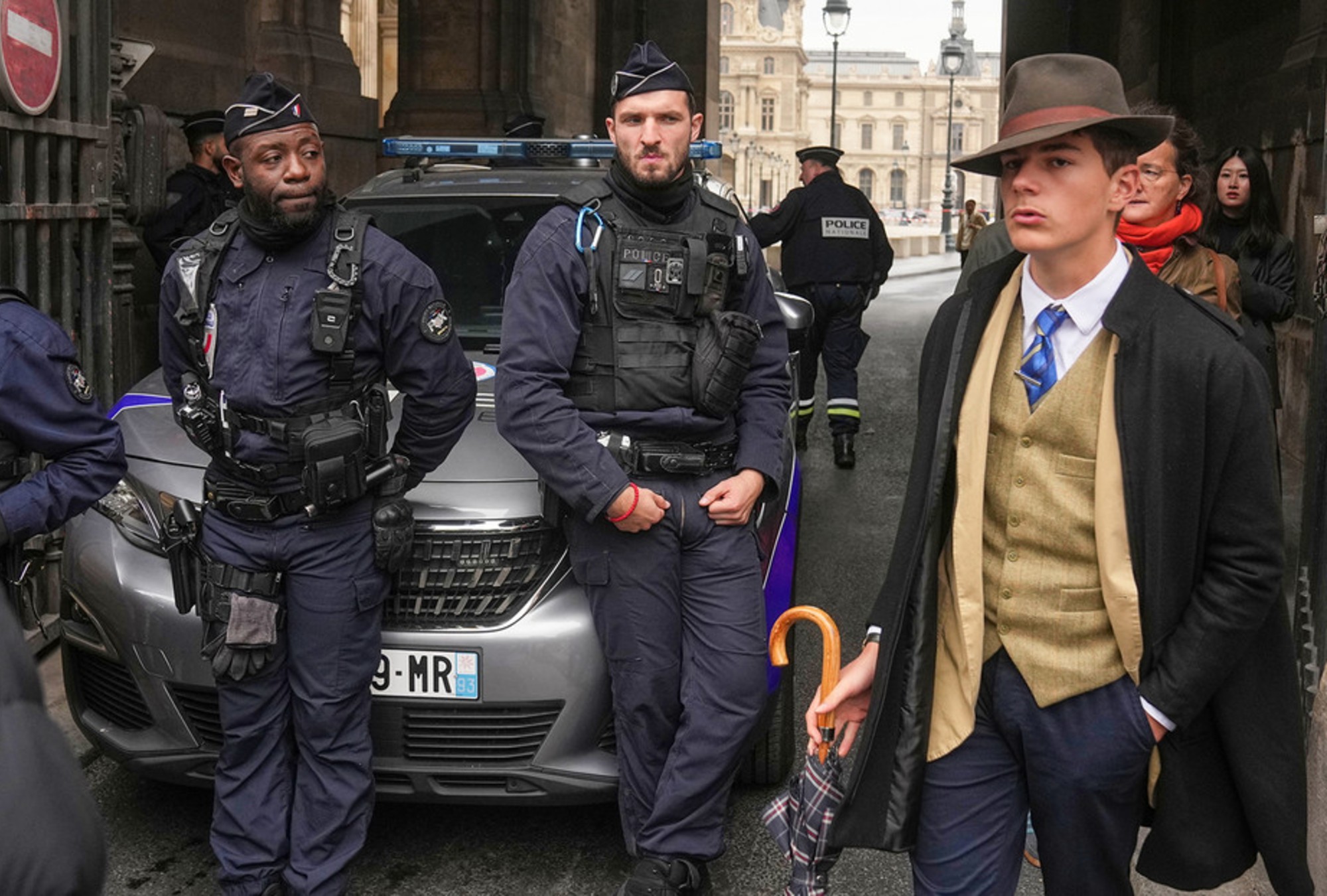 La imagen de AP que captó al “hombre del sombrero” junto a policías frente al Louvre.