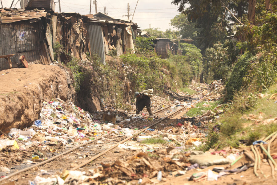 La gente camina cerca de montones de basura Nairobi Kenia África | Imagen: Depositphotos.com
